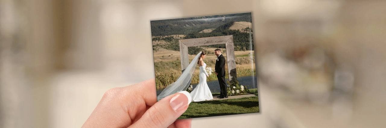 Hand holding a Magnolia magnet featuring a wedding photo